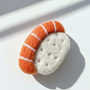 Close-up of handcrafted wool sushi magnet, needle felted salmon sushi with detailed wool texture