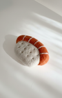 Small handmade wool sushi magnet, needle felted salmon nigiri on white background
