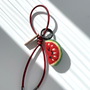 Wool felt watermelon keychain with red leather loop, handcrafted fruit bag charm accessory