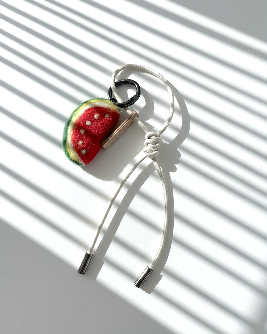 Handmade needle-felted watermelon slice keychain with white leather loop and metal ring